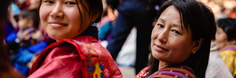 Young Bhutanese women worship at the Tshechu festival in Punakha, Bhutan.